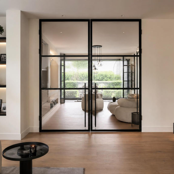 Maatwerk stalen deur met glas in een modern interieur met veel daglicht en natuurlijke materialen