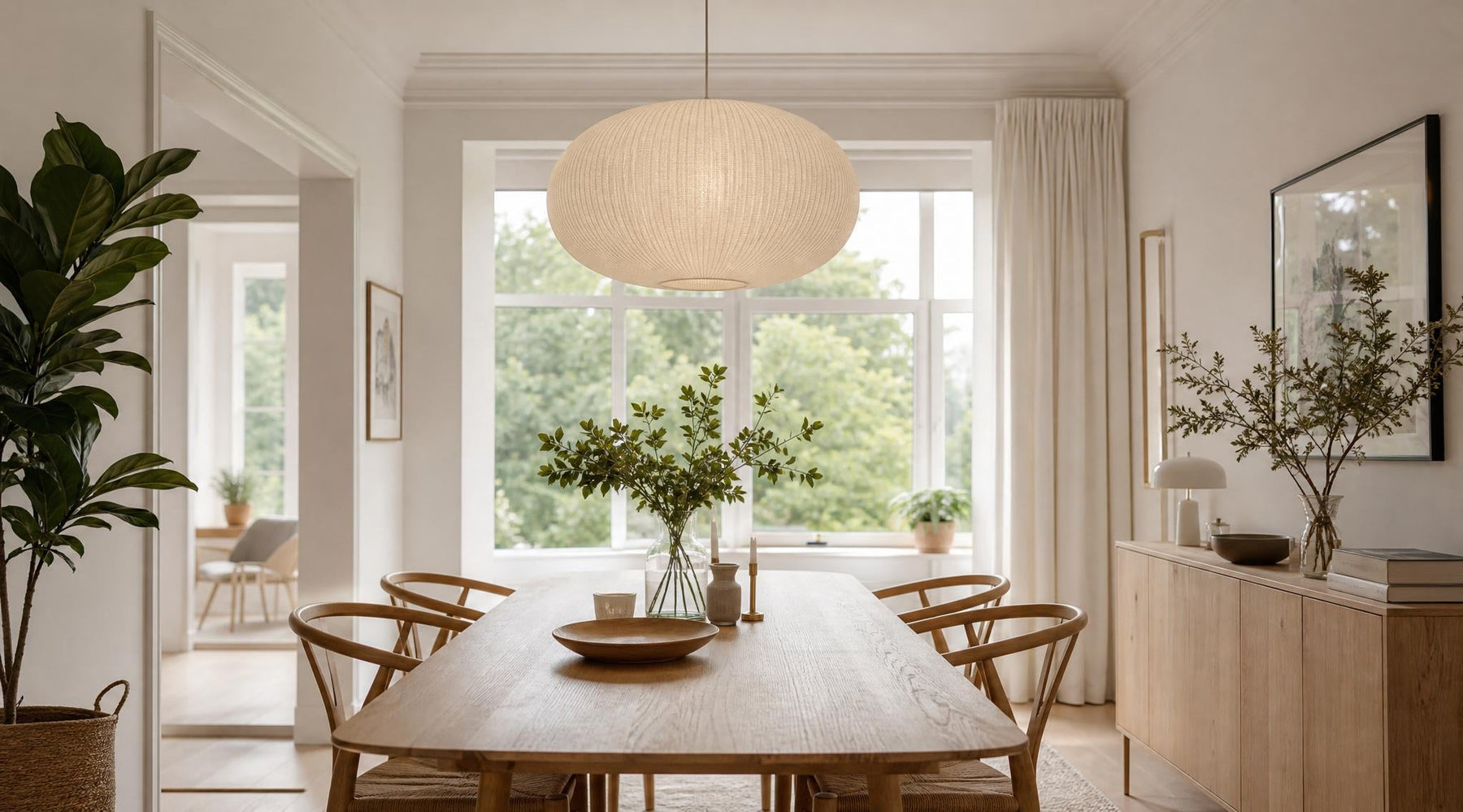 Moderne ronde hanglamp boven een houten eettafel in een stijlvol en licht interieur