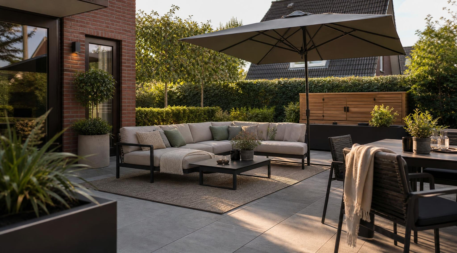 Onderhoudsvriendelijke buitenkamer met loungeset, parasol en buitenkleed