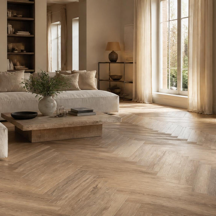 Ruime woonkamer met een visgraatvloer in warme natuurlijke tinten en luxe rustige inrichting.