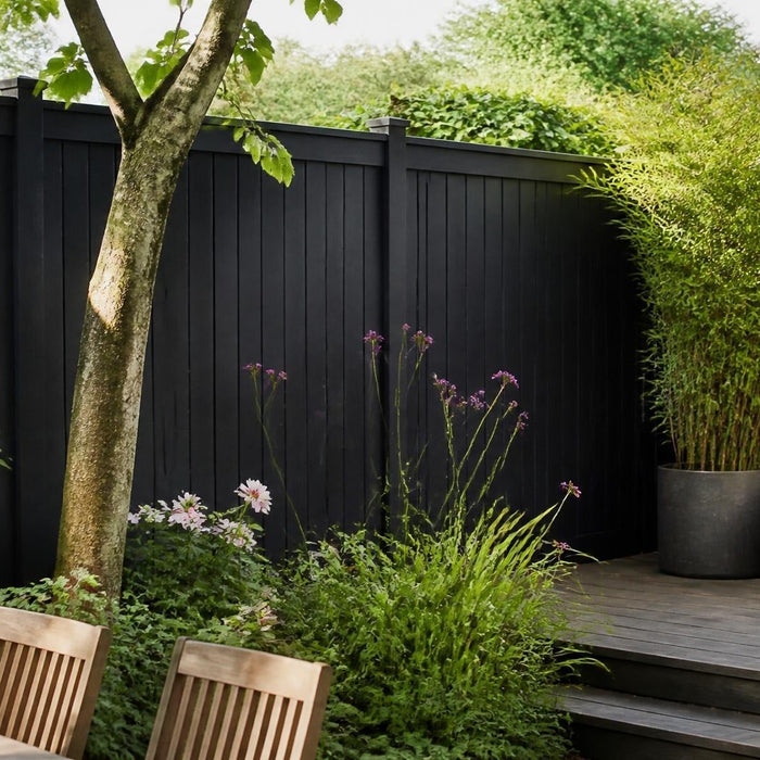 Stijlvolle Nederlandse tuin met een strak geschilderde houten schutting in warm daglicht