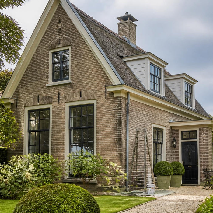 Stijlvolle woning met geschilderde kozijnen en deur op een droge, milde dag.