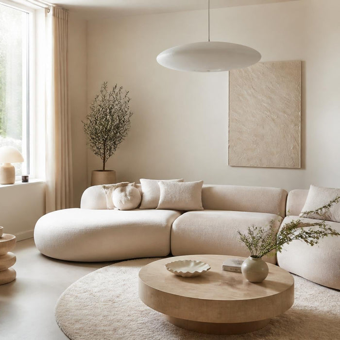 lichte woonkamer met neotenic design ronde meubels bouclé fauteuil en warme neutrale tinten